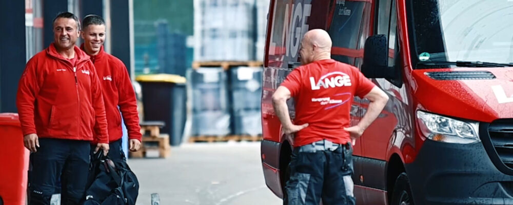 Lange Mitarbeiter vor einem Transporter