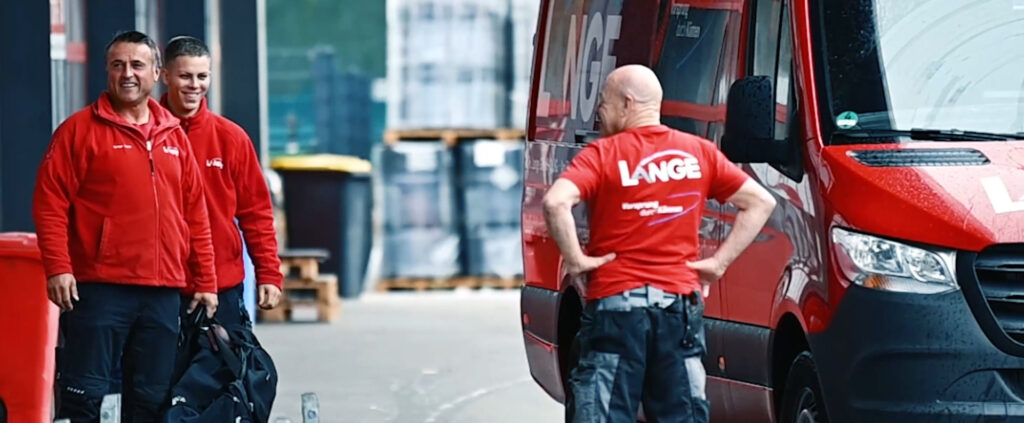 Lange Mitarbeiter vor einem Transporter