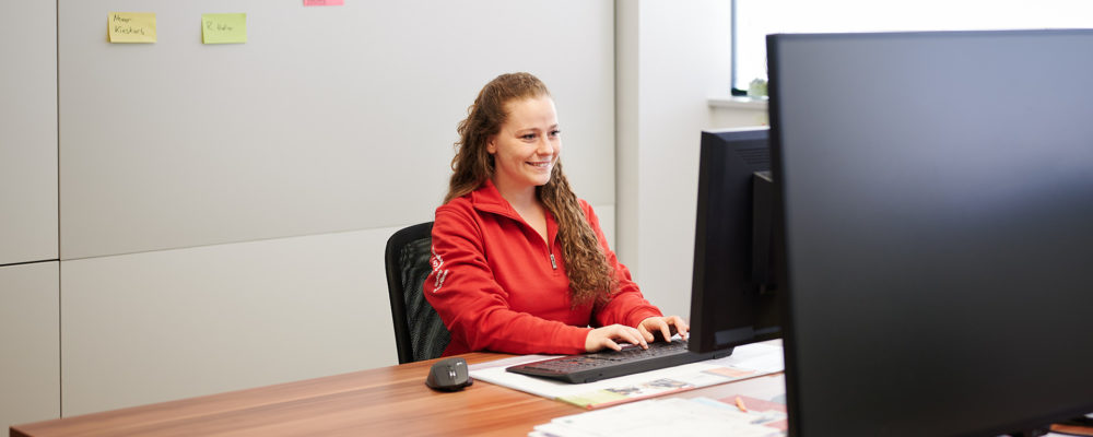 Lange Mitarbeiterin arbeitet an einem PC